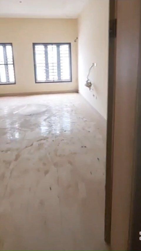 A large empty room with a door and two windows.