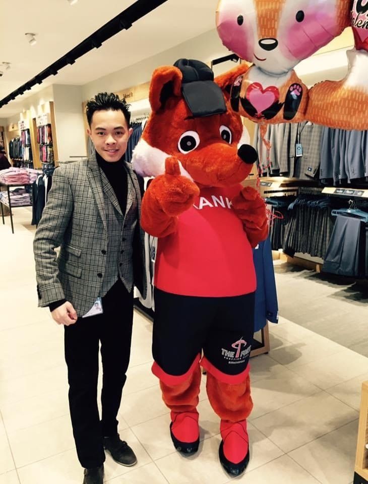 Young man with a cartoon character mascot