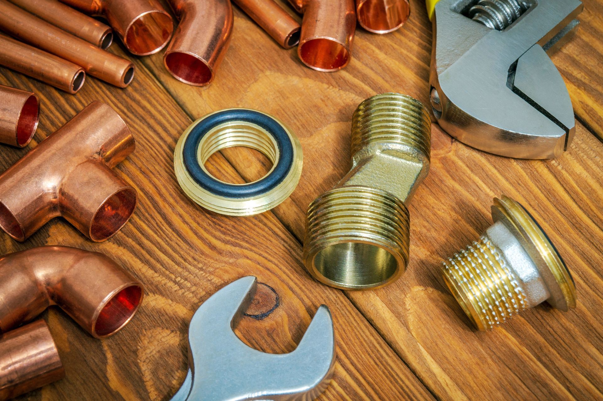 Spare parts with copper and brass fittings, showcasing plumbing supply on vintage wooden boards.