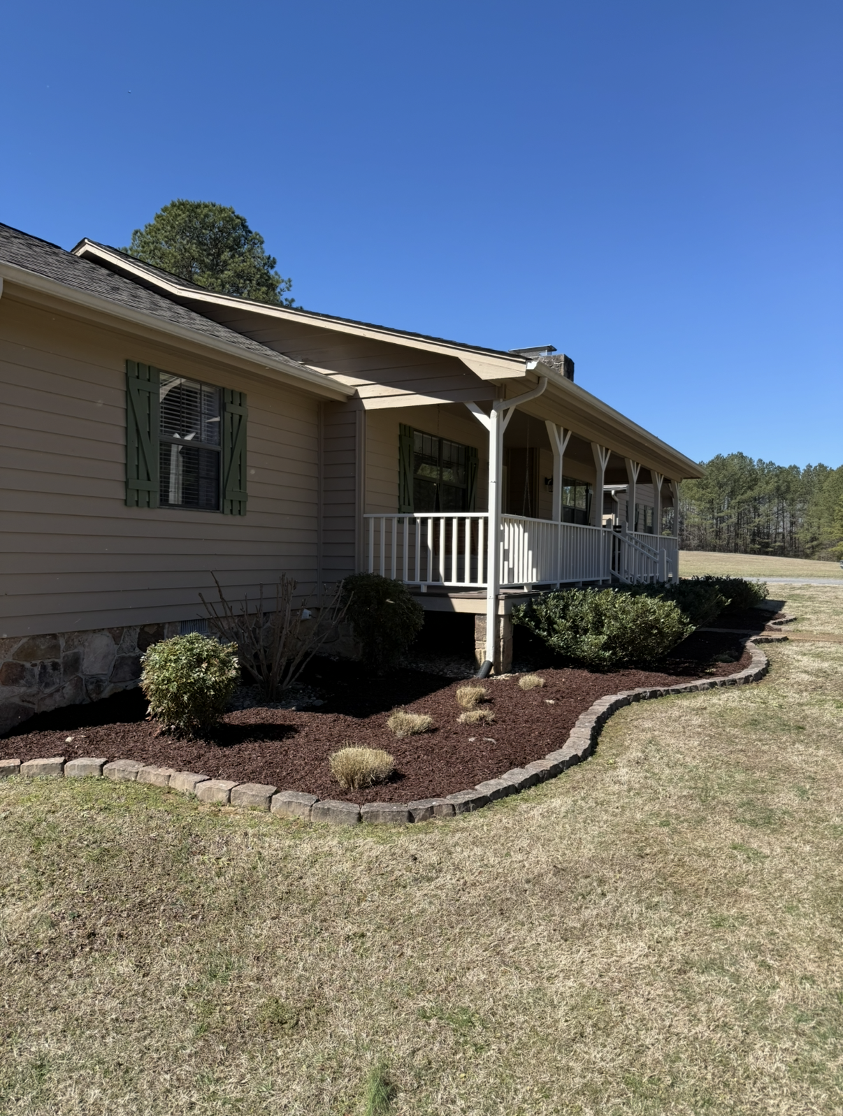 Mulched flower beds at a home in Cleveland, TN by Stripes & Edges