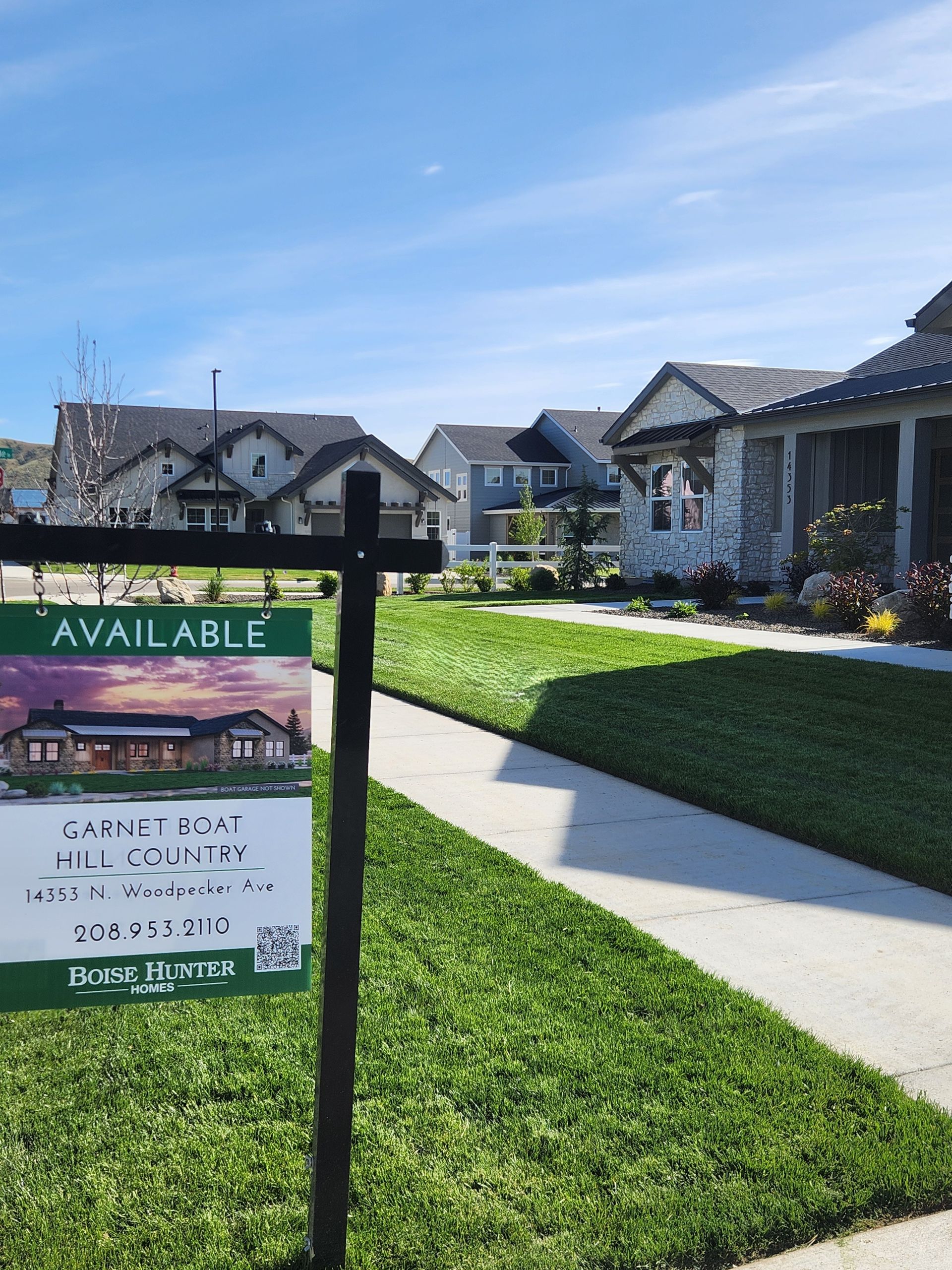 A for sale sign is sitting in front of a model home.