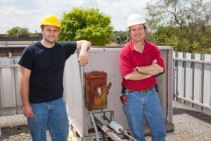 Two men wearing hard hats are standing next to each other.