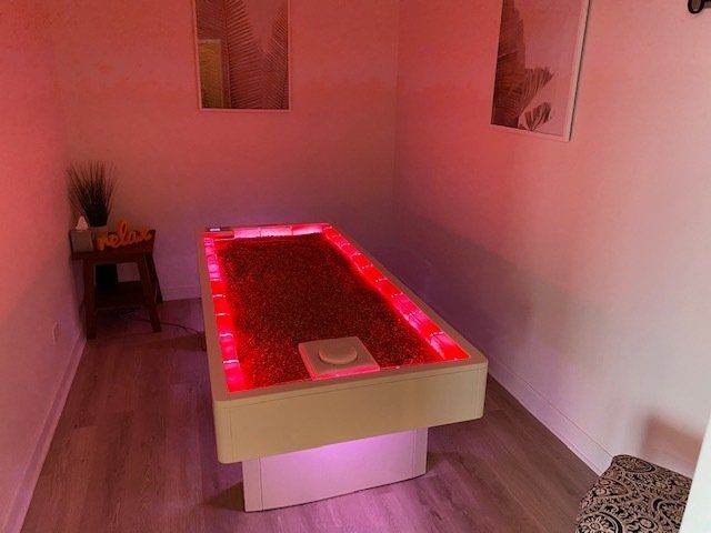 young lady laying on her stomach on a relaxing bed made out of himalayan pink salt during a himalayan salt bed session.