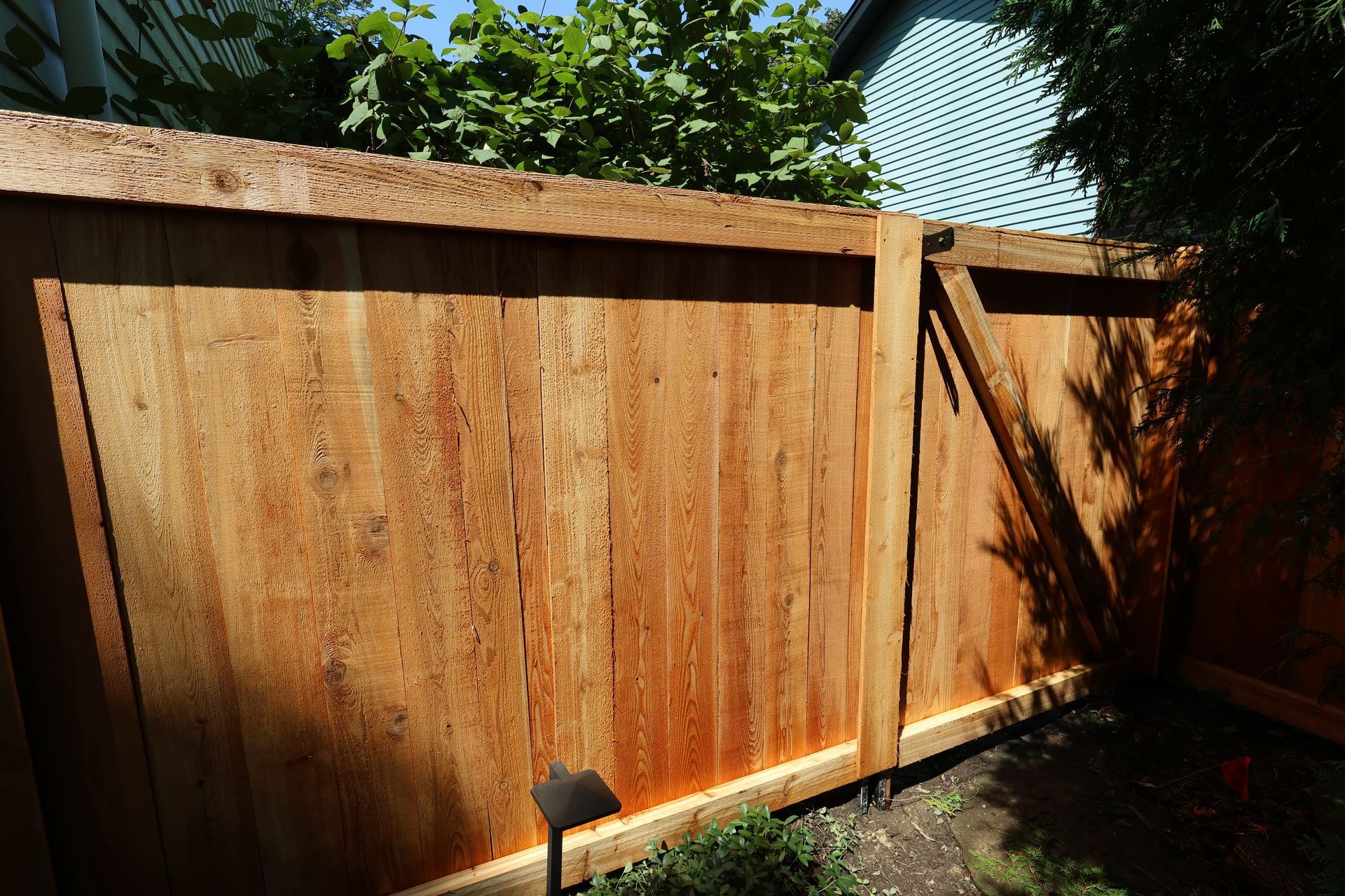 A wooden fence with a light on the side of it