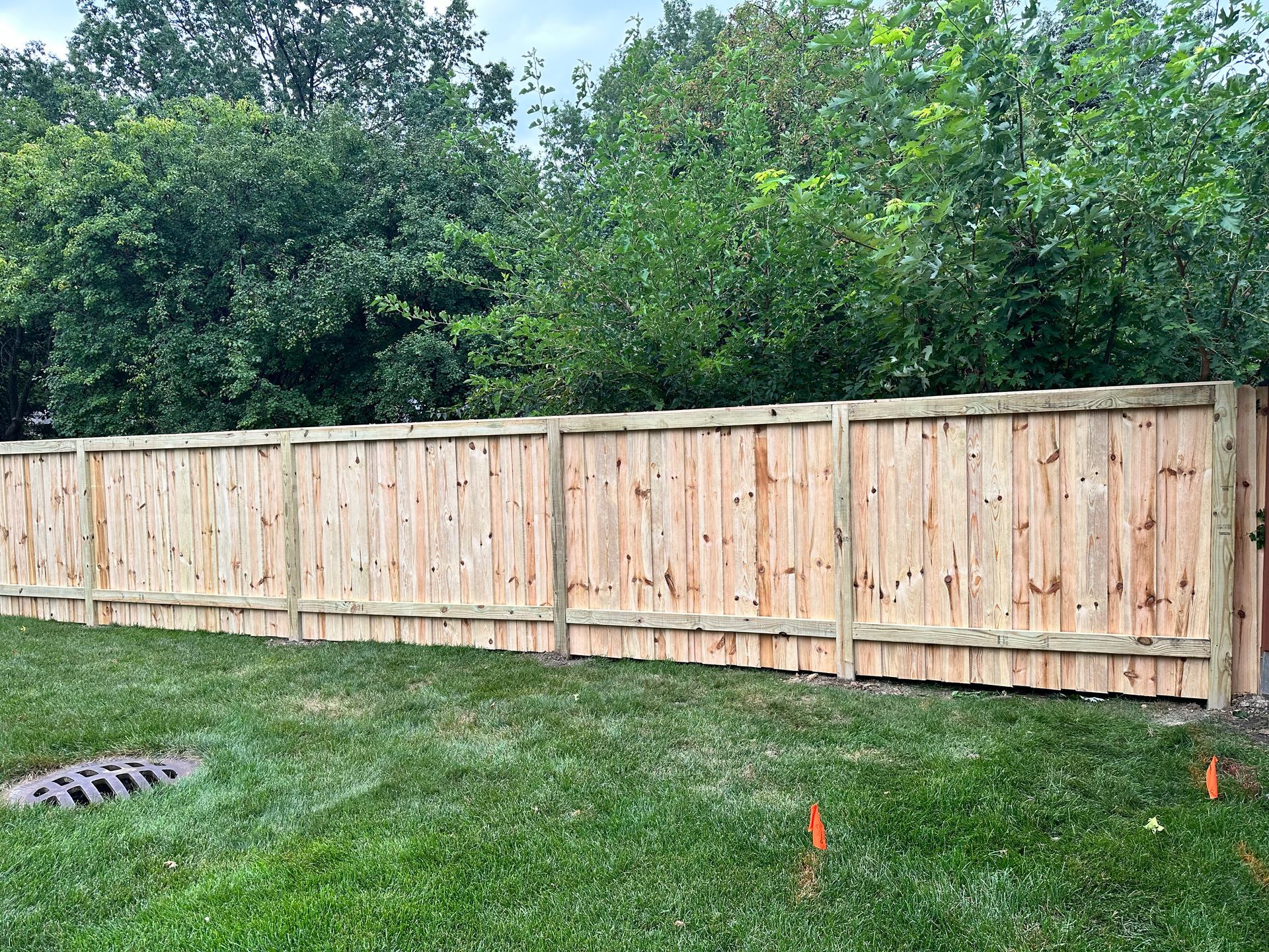A wooden fence is sitting in the middle of a lush green field.
