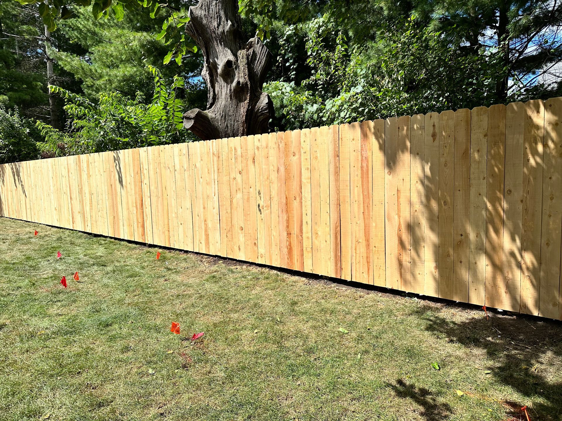 A wooden fence is sitting in the middle of a lush green field.