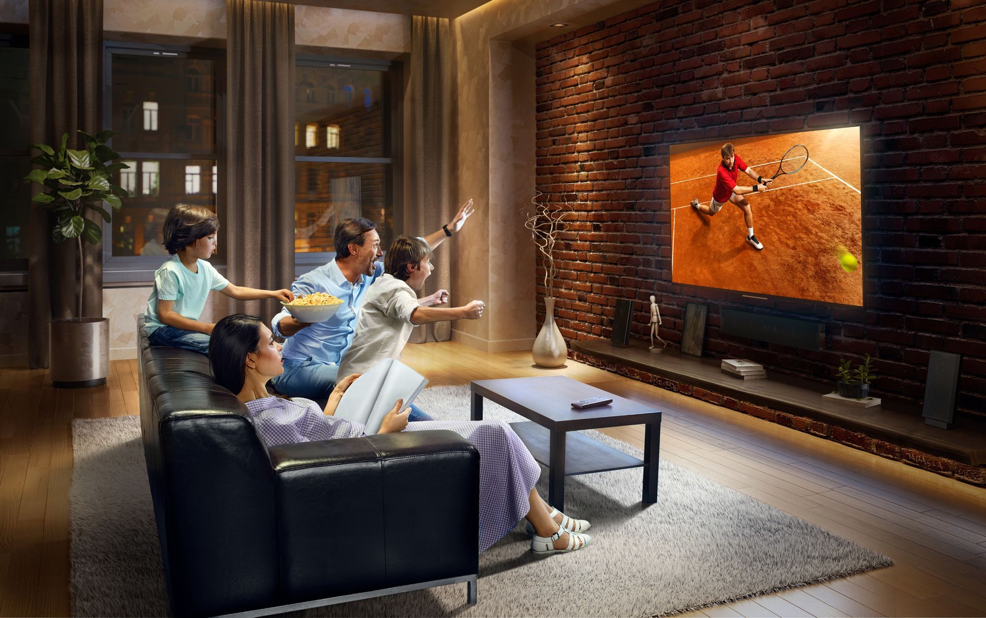 A family is sitting on a couch watching a tennis match on a television.