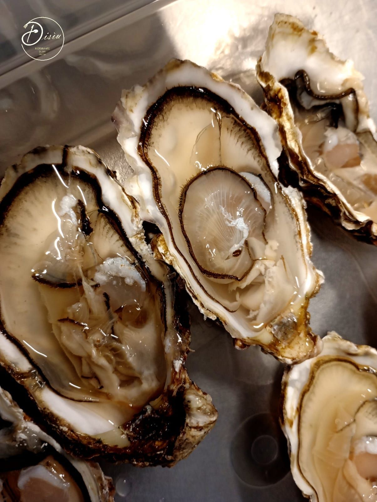 Ostriche aperte con polpa visibile, che mostra il liquido salato.