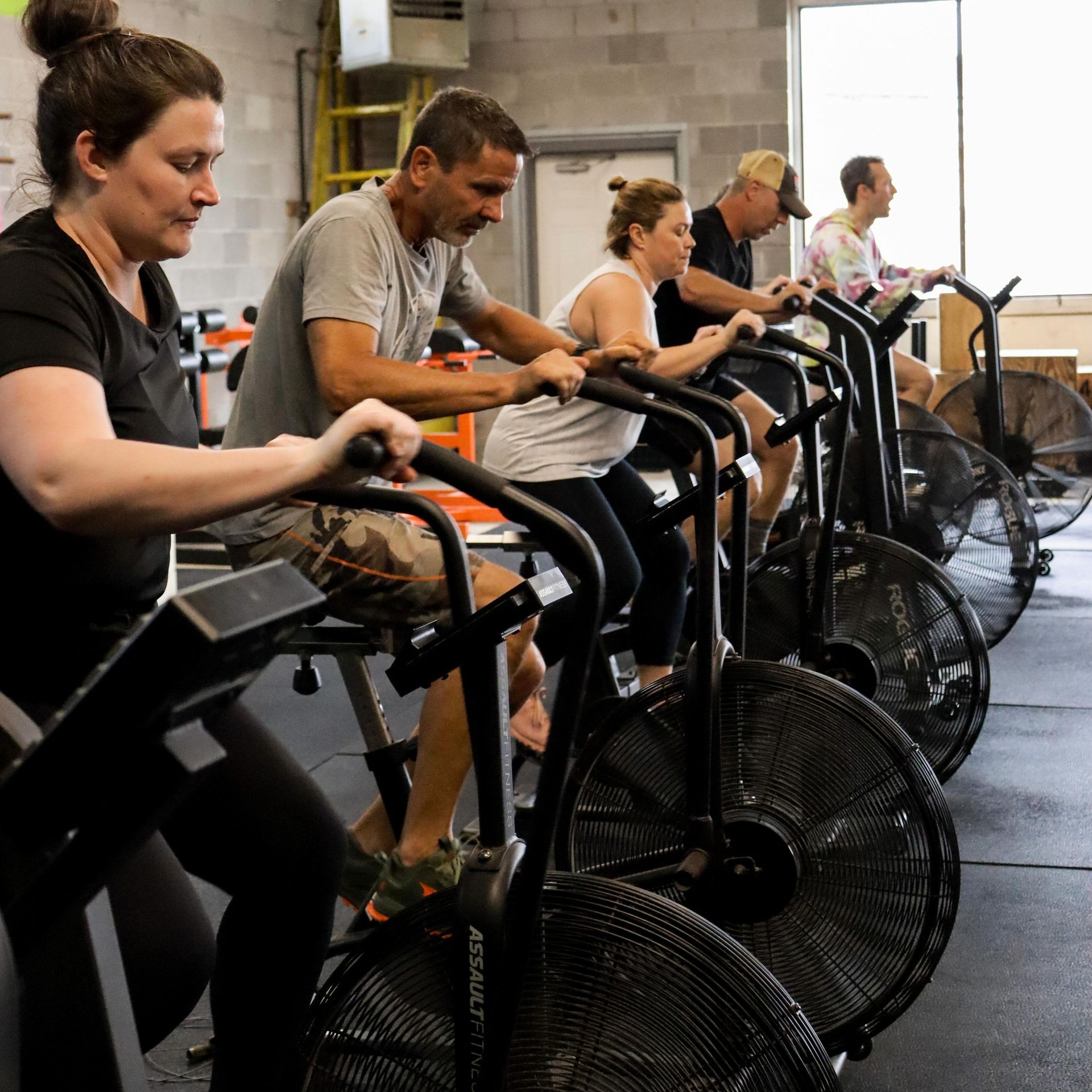 A group of people are riding exercise bikes in a gym