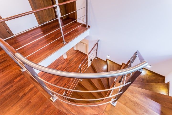 A beautiful spiral staircase with polished wood and sleek railings