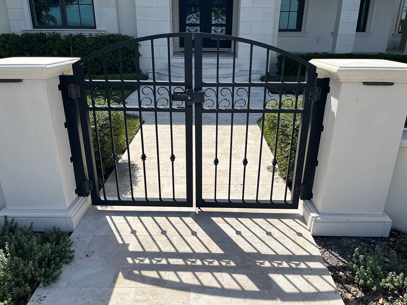 Decorative iron gate set in white stone wall