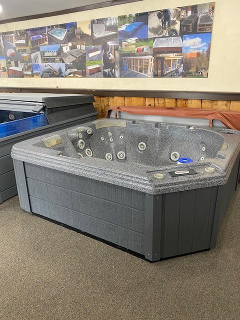 Gray hot tub with multiple jets in a showroom.