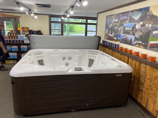 A large, brown and white hot tub on display inside a store.