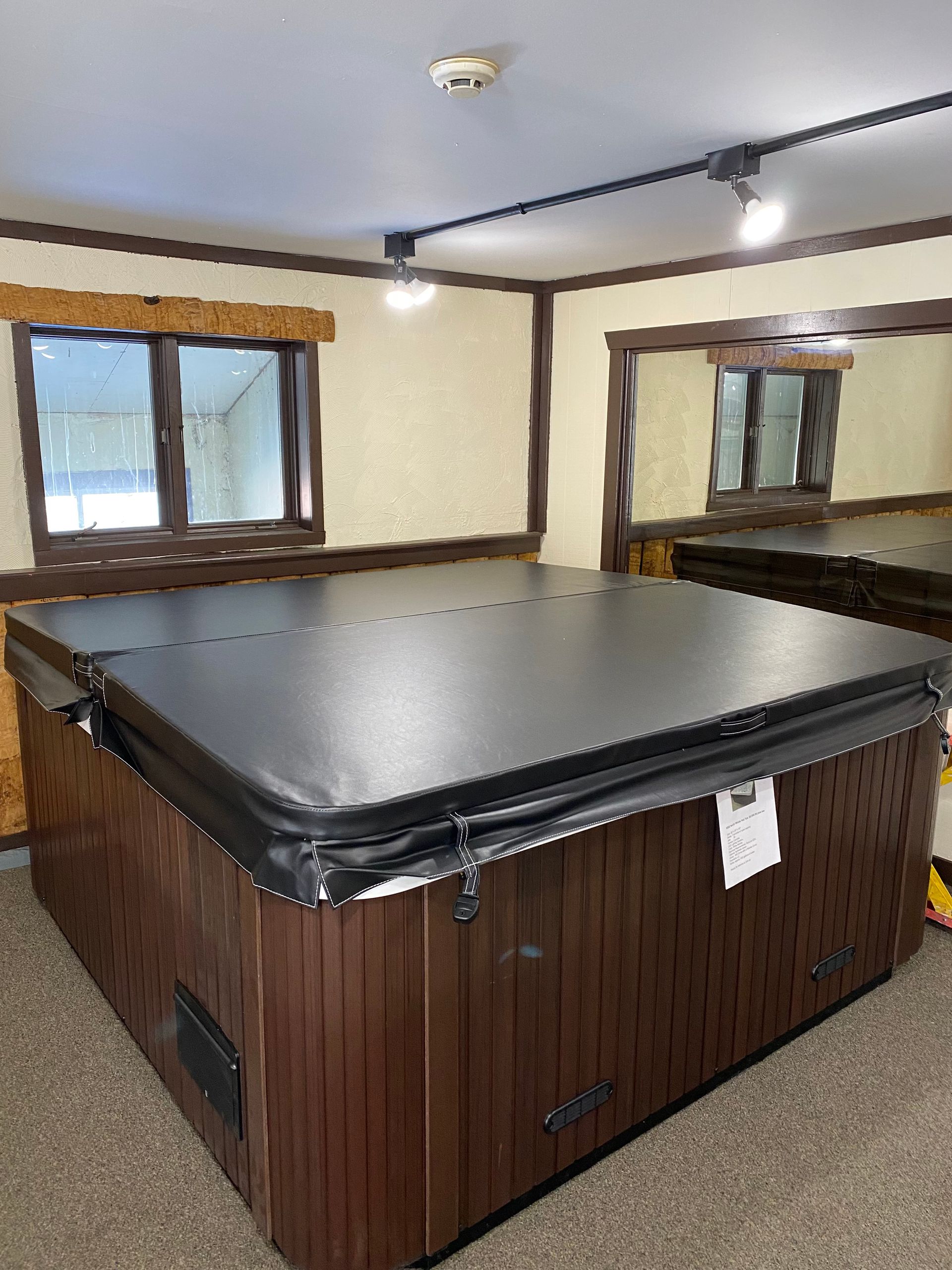 Gray shed on a concrete pad next to a house. Gravel and retaining wall are in the foreground.