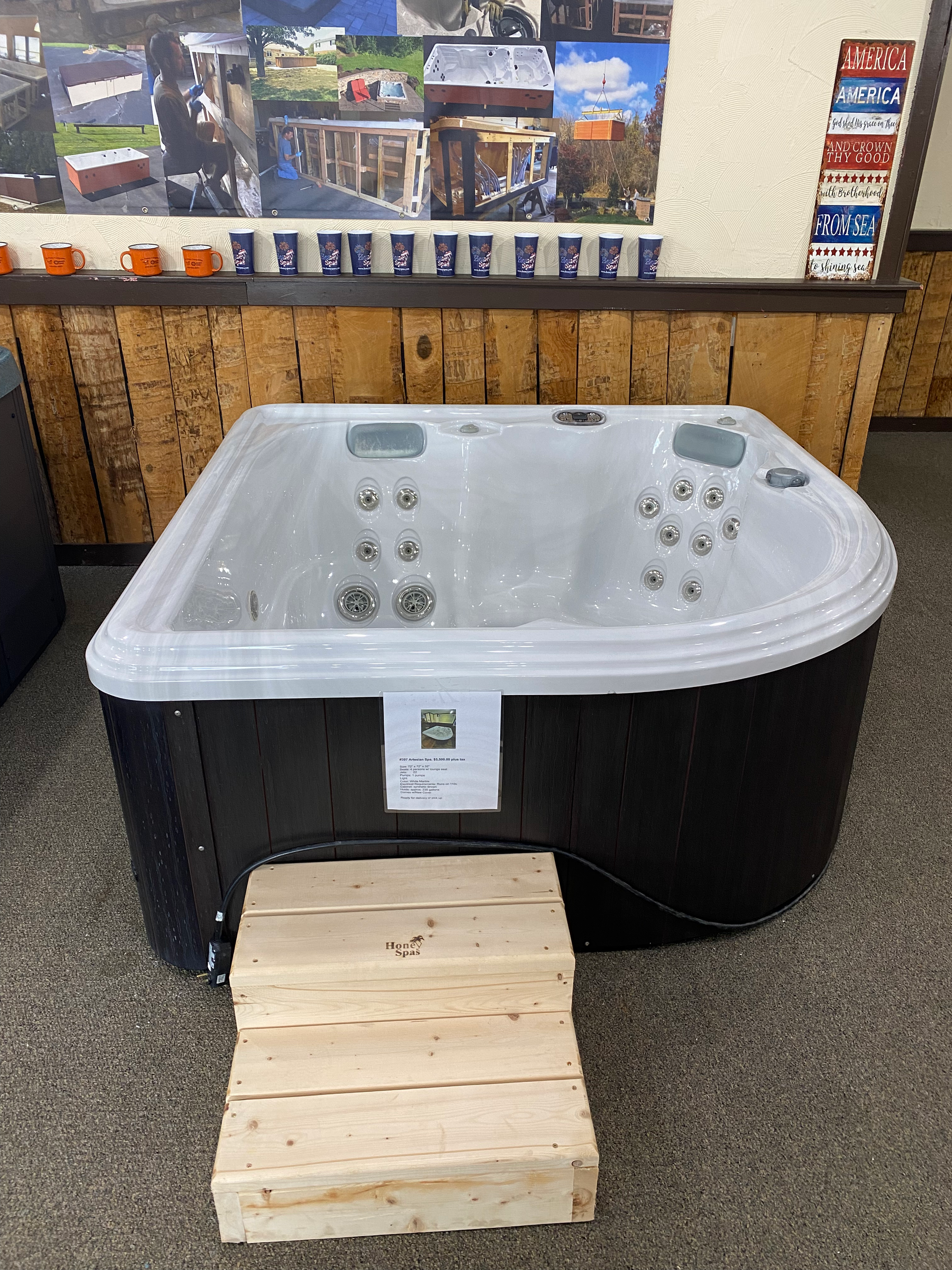 A small, gray hot tub with a black cover sits indoors.