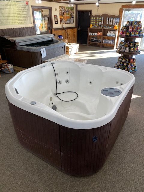 A brown and white hot tub on display inside a store.