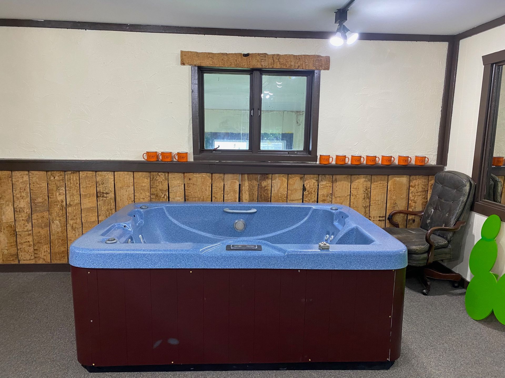 Hot tub in a room with wood paneling, brown and blue colors.