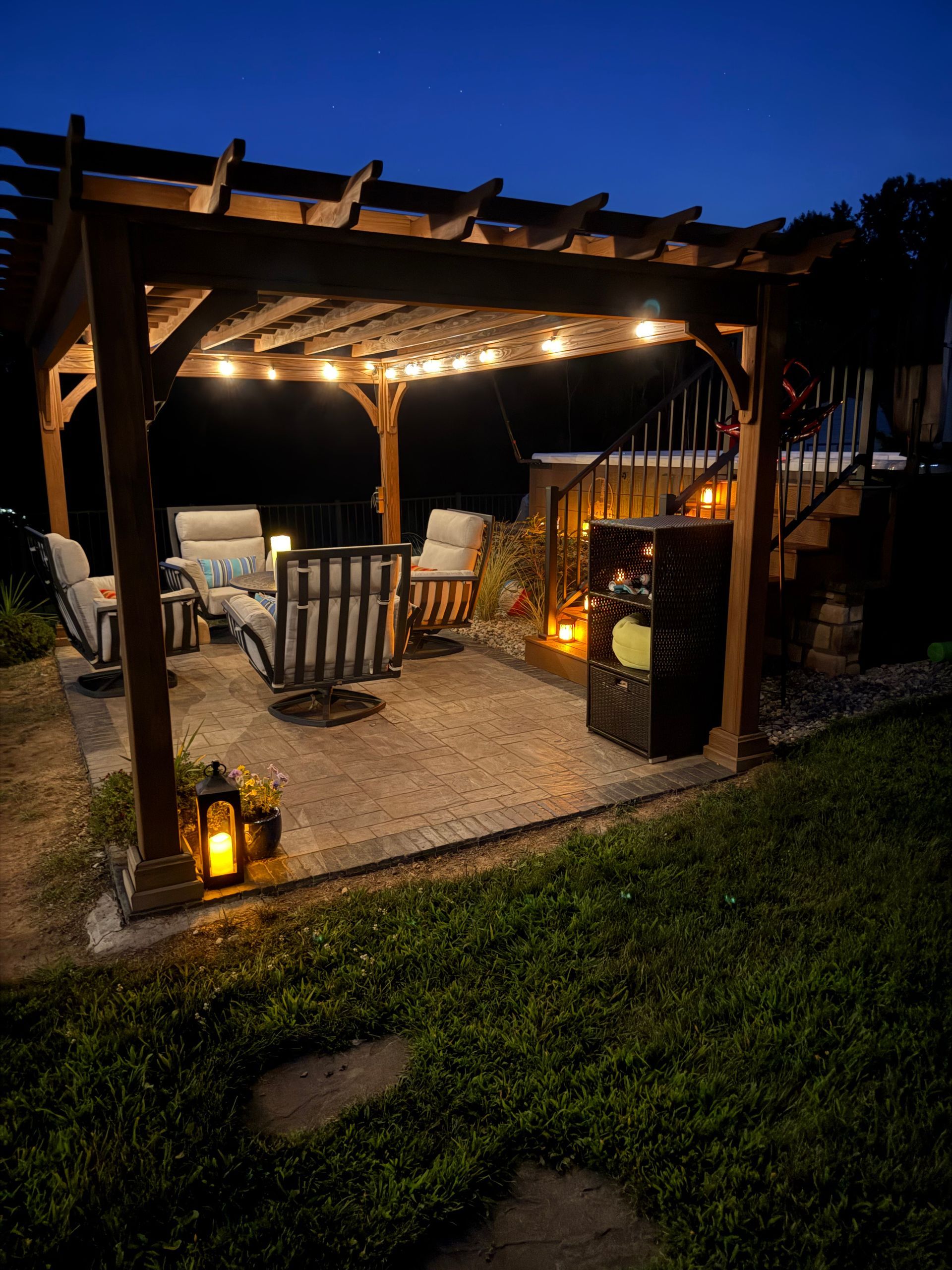 A large gray hot tub next to a building with gray siding, on a bed of rocks.