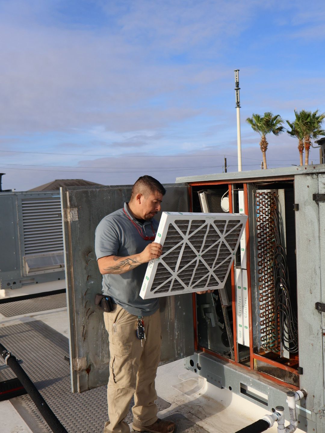 Home owner inspecting AC filter unit in Corpus Christi, TX.