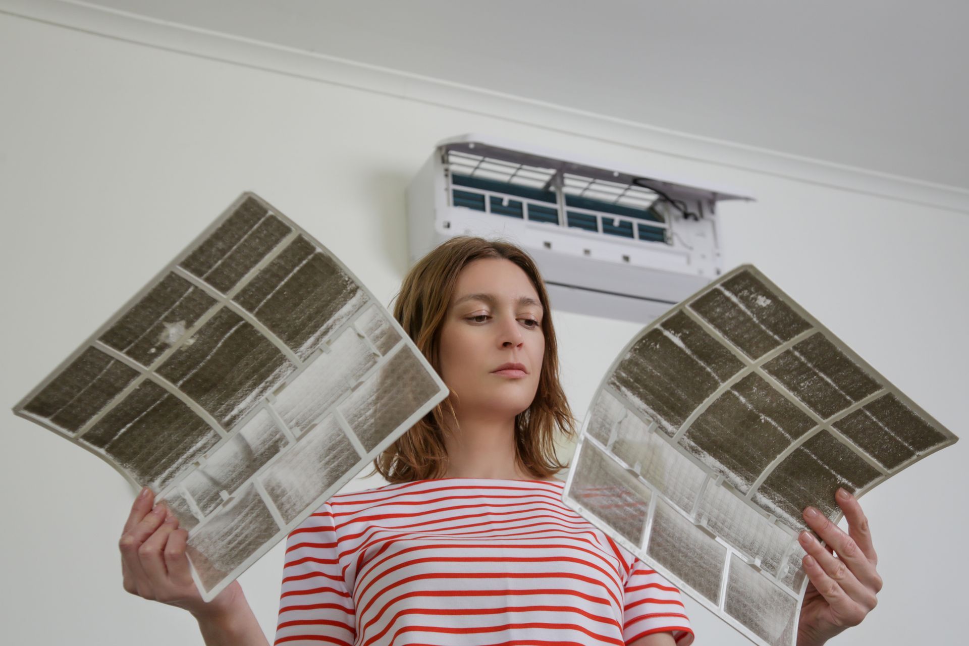 Home owner inspecting AC filter unit in Corpus Christi, TX.