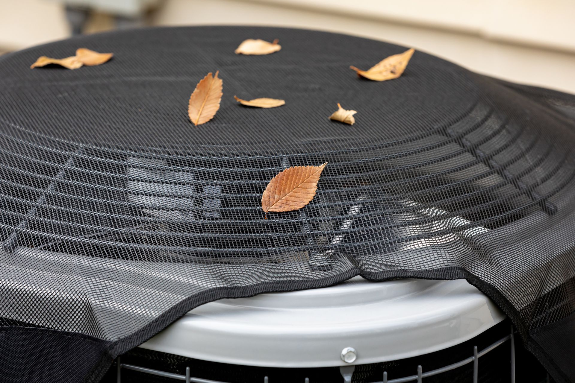 House air conditioning unit with protective mesh cover during fall season in Corpus Christi, TX.