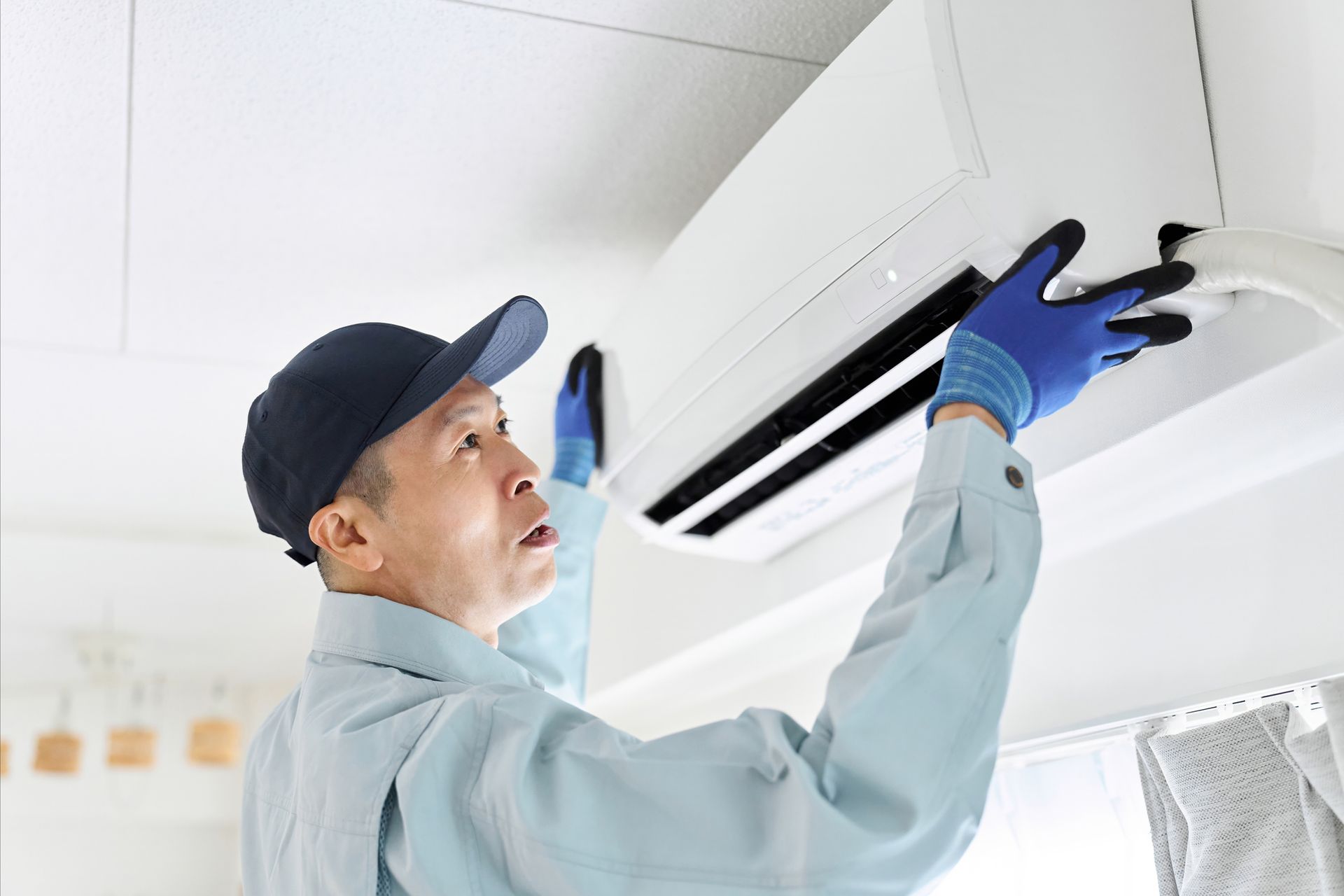 HVAC technician installing a new air conditioning unit in a Corpus Christi home during spring.