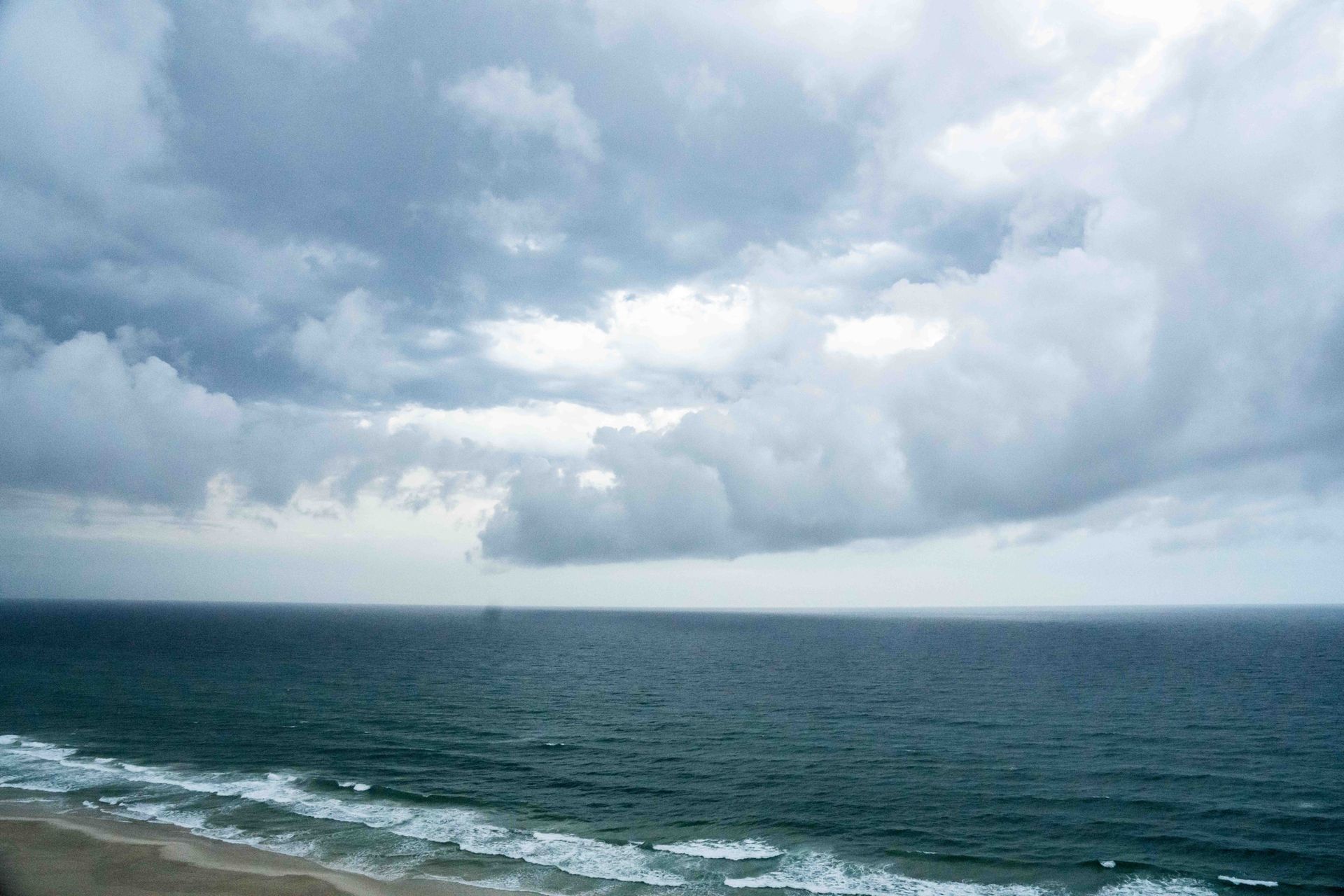 Heavy coastal storm clouds and humid Gulf Coast weather impacting HVAC system performance.