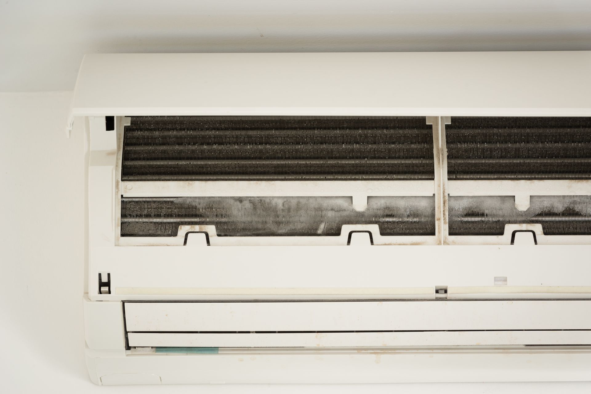 Frozen evaporator coil inside air conditioning system showing ice buildup caused by airflow issue,