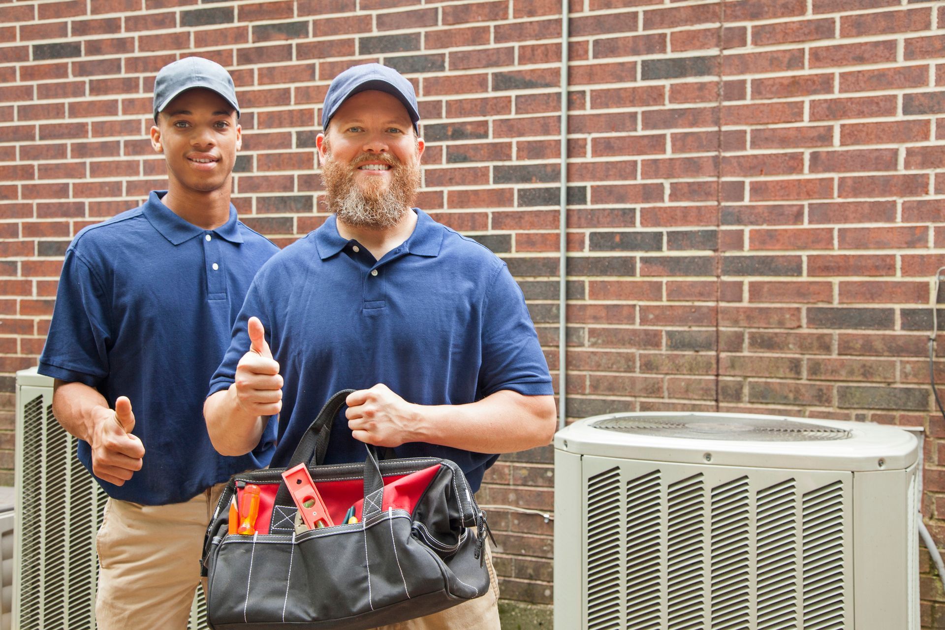 Air conditioner repairmen work on home unit.