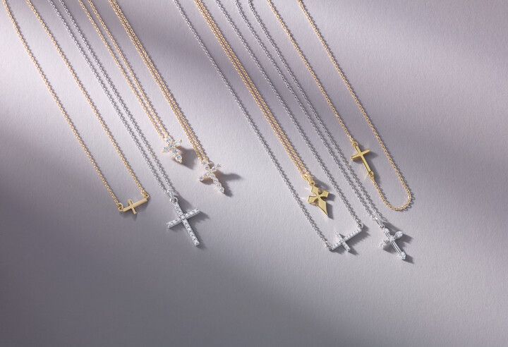 A group of necklaces with crosses on them are sitting on a table.