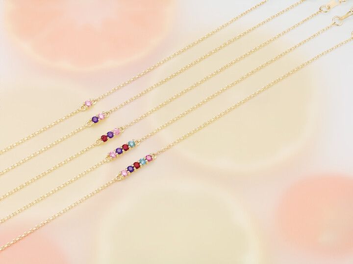 A close up of three bracelets on a white surface.