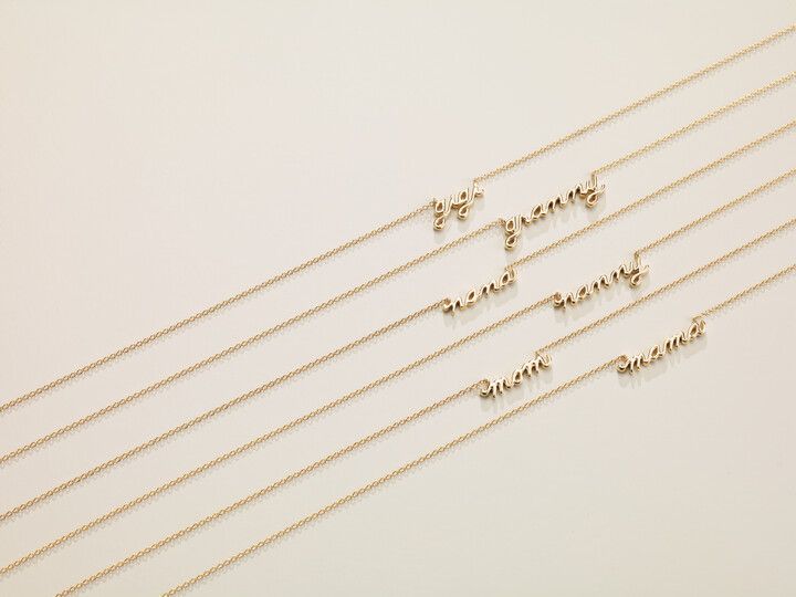 A close up of a row of necklaces on a white surface.