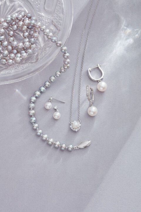 A close up of a necklace , earrings , and bracelet on a table.