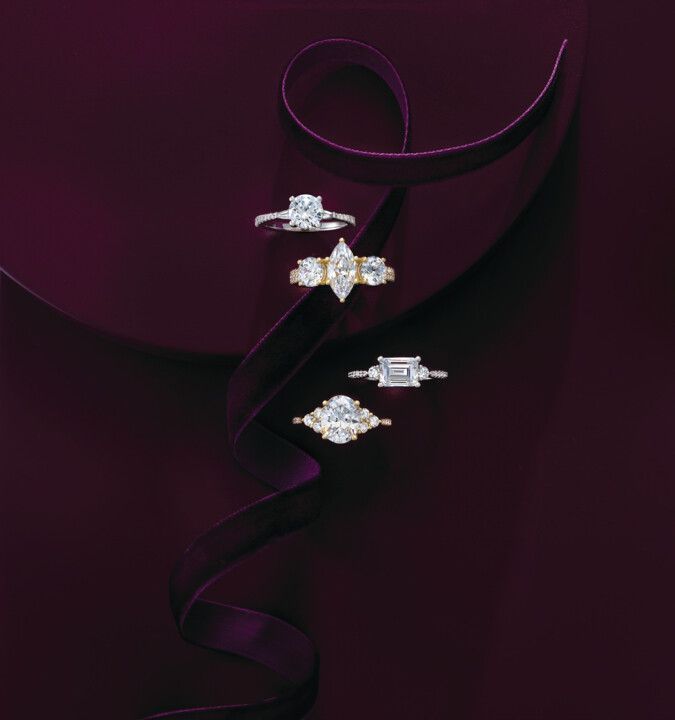 A group of rings sitting on top of a purple cloth