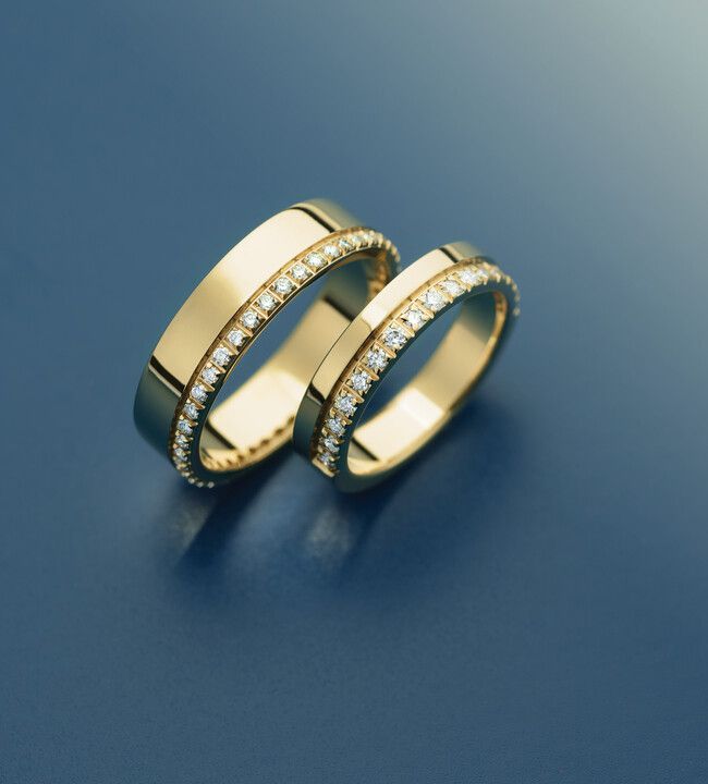 A couple of gold rings on a blue surface