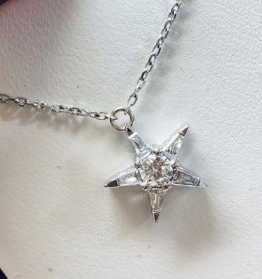 A necklace with a star shaped pendant on a chain