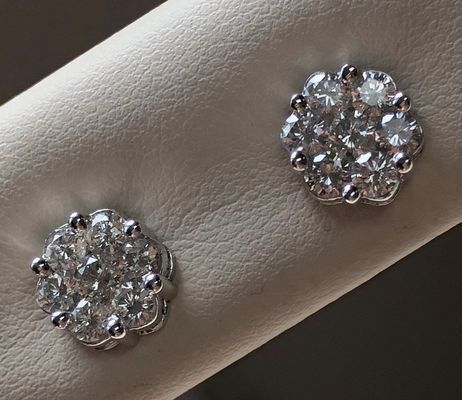 A pair of diamond stud earrings on a person 's wrist