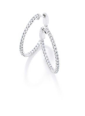 A pair of white gold hoop earrings with diamonds on a white background.