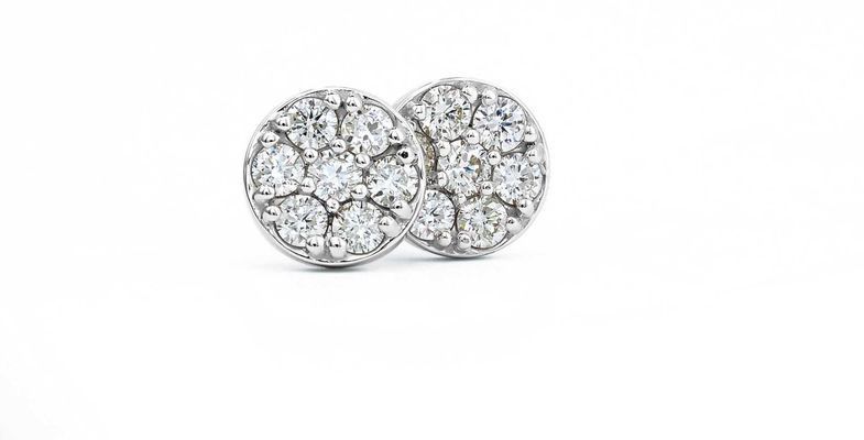 A pair of diamond stud earrings in white gold on a white background.