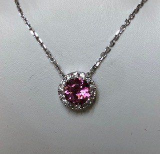 A necklace with a pink stone and diamonds on a chain