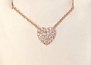 A close up of a necklace with a heart shaped pendant on a chain.