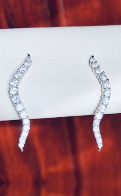 A pair of earrings are sitting on a white cloth