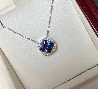 A sapphire and diamond necklace is in a box.