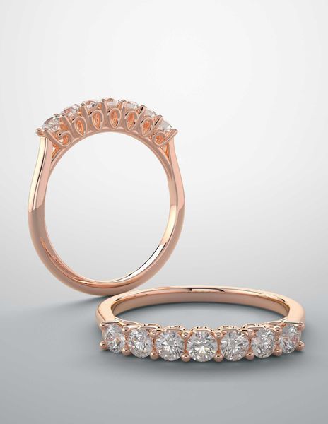 A rose gold ring with a row of diamonds on it