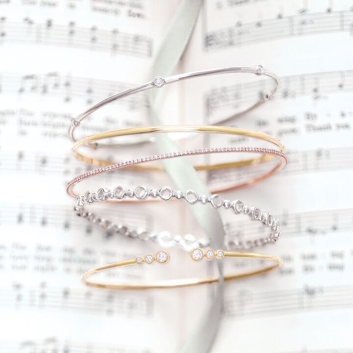 A stack of bracelets sitting on top of a sheet of music.