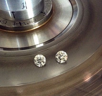 Two diamonds are sitting on top of a metal surface