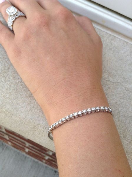 A woman wearing a bracelet and a ring on her wrist