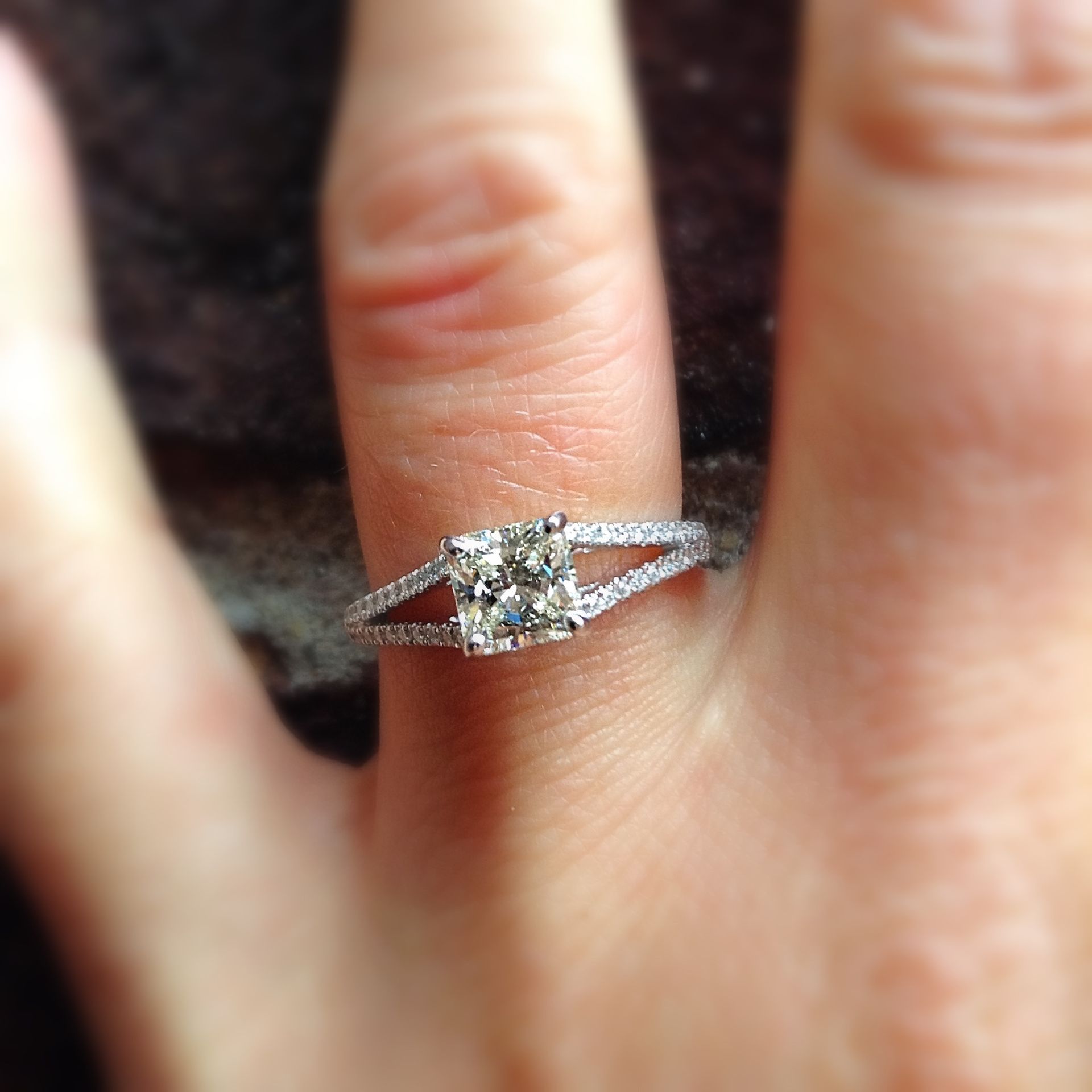 A woman is wearing a diamond ring on her left hand