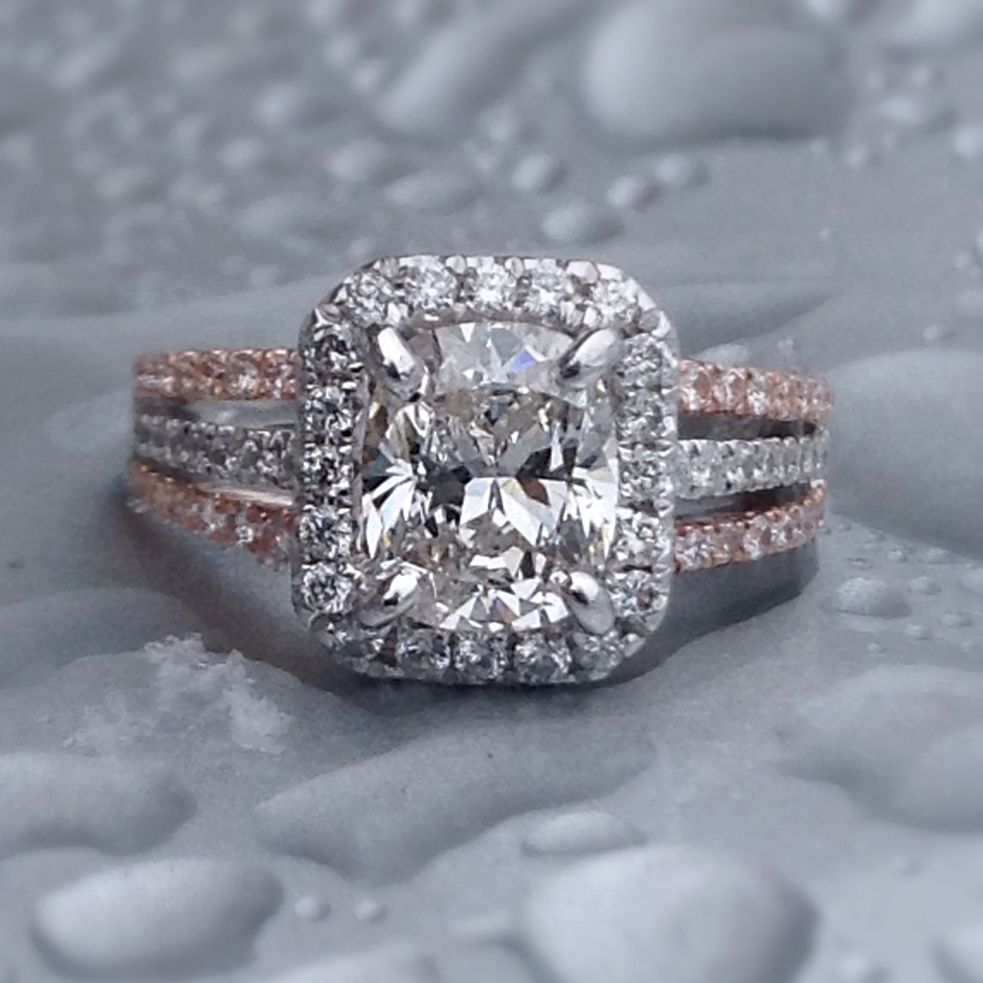 A diamond ring with a cushion cut diamond in the center