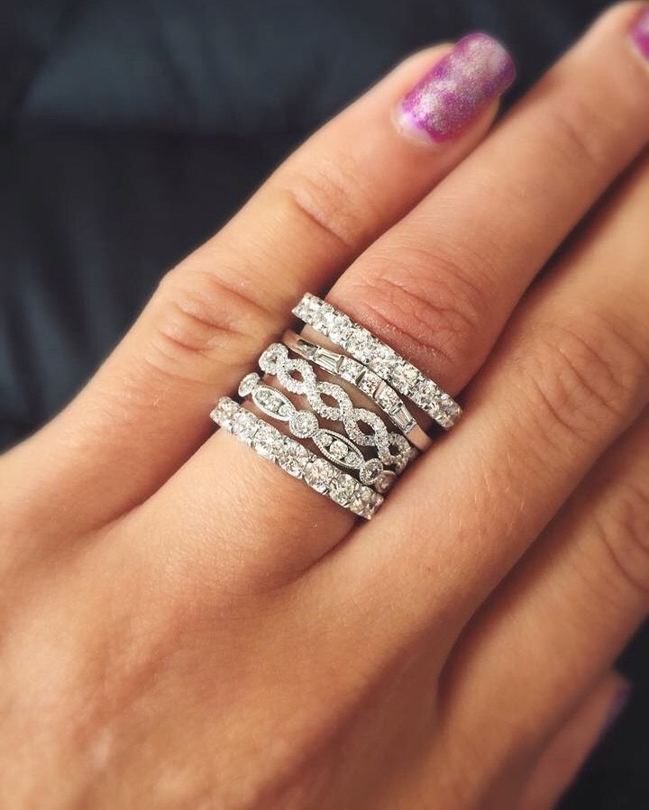 A woman 's hand with a stack of rings on it